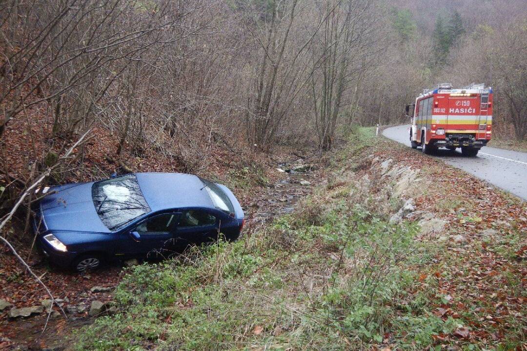 FOTO: Po dopravnej nehode v Zliechove skončilo auto v potoku. Vytiahnuť ho museli pomocou hydraulickej ruky